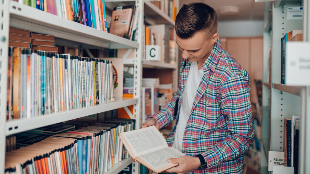 Valmieras tehnikuma audzēknis lasa grāmatu Valmieras tehnikuma bibliotēkā.